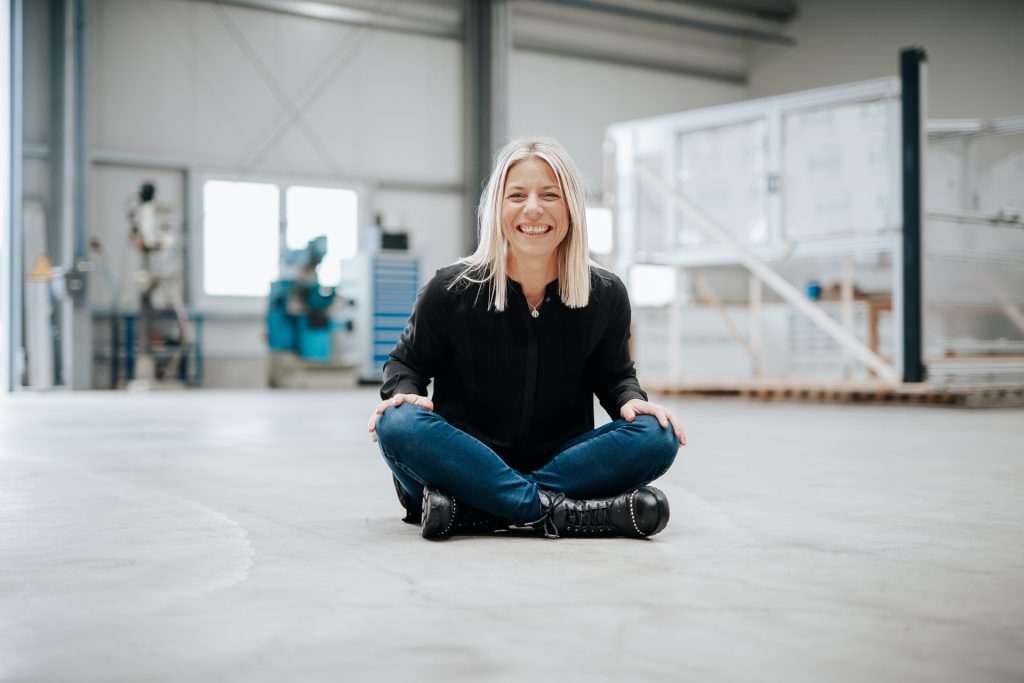 Businesscouach sitzt in einer Halle auf dem Boden während eines Businessshootings in Bonn.